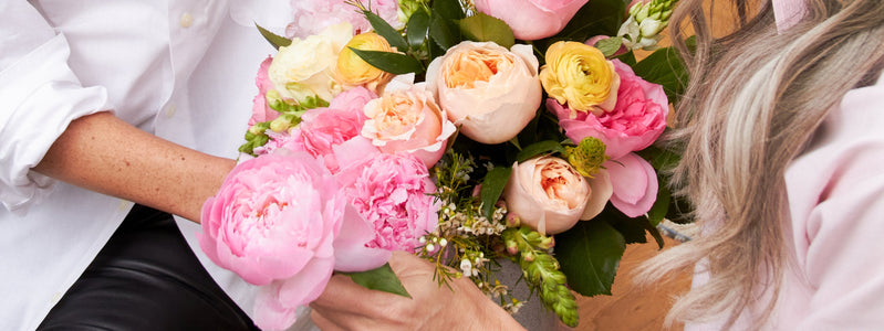 Woman gifting her mom Mother's Day flowers from UrbanStems.