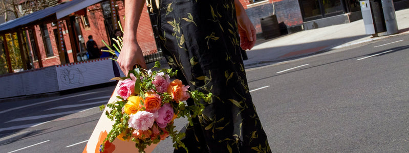 Woman carrying UrbanStems Mothers Day flowers for 2023