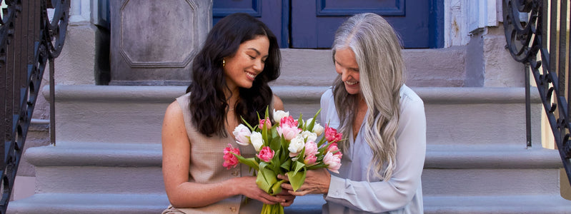 Close up of a mother and daughter exchanging flowers for Mother's Day.