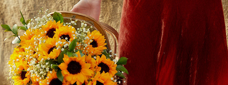 Woman carrying a basket full of sunflowers