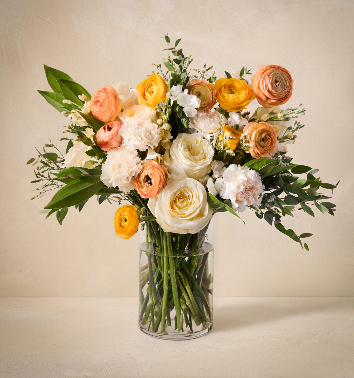 Bouquet of flowers in a clear vase on a light background