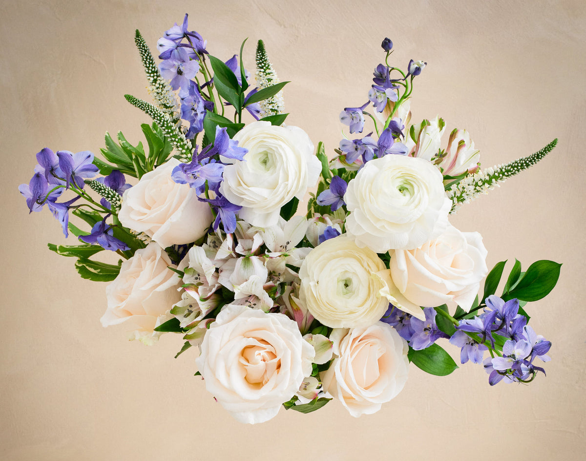 Bouquet of white and purple flowers on a beige background