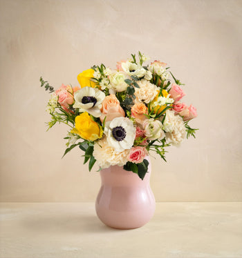 Bouquet of flowers in a pink vase on a beige background