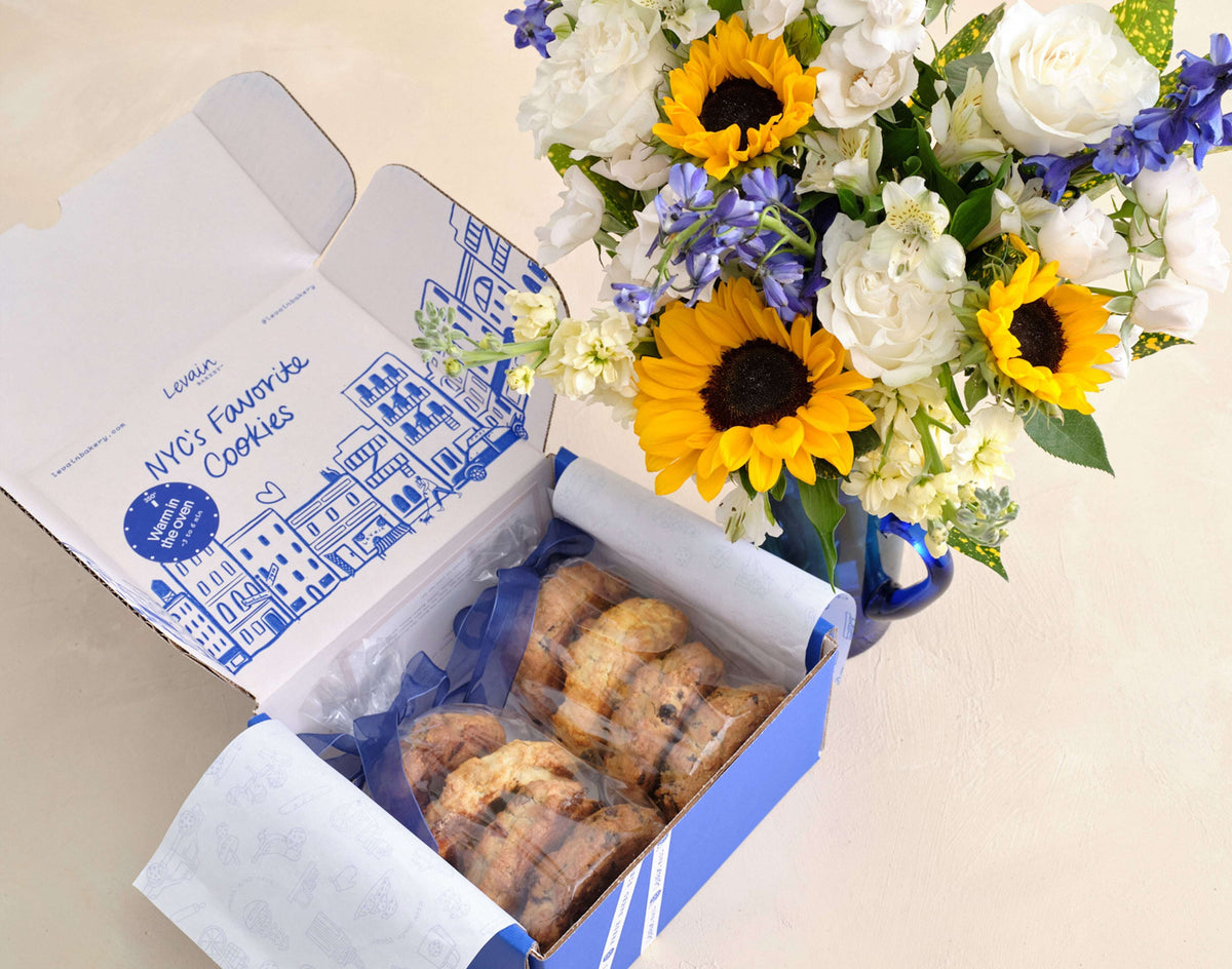 Box of cookies with a bouquet of flowers on a light background